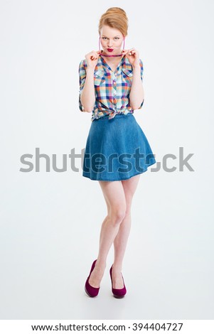 Full length portrait of a charming young woman looking at camera isolated on a white background