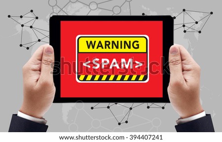 WARNING SPAM CONCECT on the tablet pc screen held by businessman hands , top view