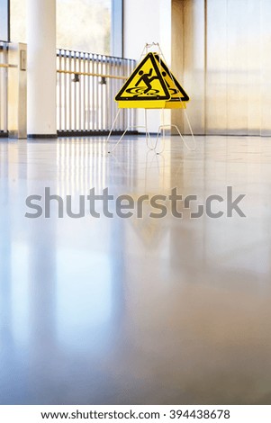 Sign for danger in the hallway with large windows, mirroring and Lift