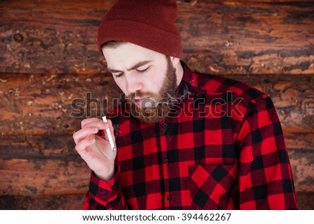 Man hipster smoking on wooden background