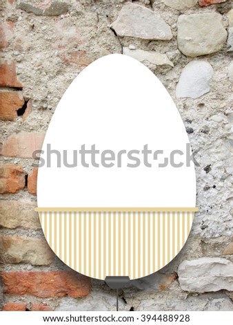 Close-up of one hanged decorated Easter egg blank frame with clip against weathered brick wall background