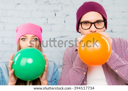 Close up photo of two lovers inflating balloons for celebration