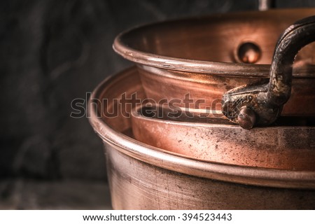 Copper pots and pans on the blurred background Royalty-Free Stock Photo #394523443