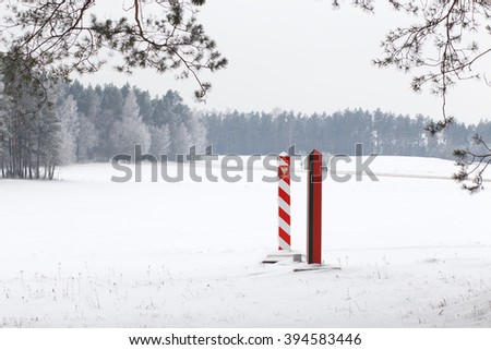Boundary pillars of Belarus and Poland on the border in a winter field