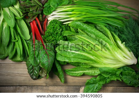 Spring vitamin set of various green leafy vegetables on rustic wooden table. Top view point. Royalty-Free Stock Photo #394590805