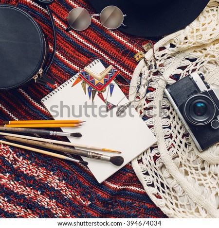 Objects top view  lifestyle essentials  of  artist girl or woman. Objects for painting, writing and sketching .Knitted sweater, bohemian stile. Retro vintage film camera,  art brushes.  