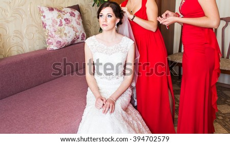 Bridesmaid helping the bride with veil