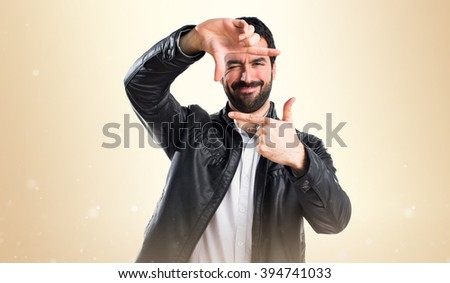 Man with leather jacket focusing with his fingers