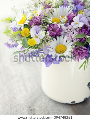 Wild flower bouquet on vintage wooden background