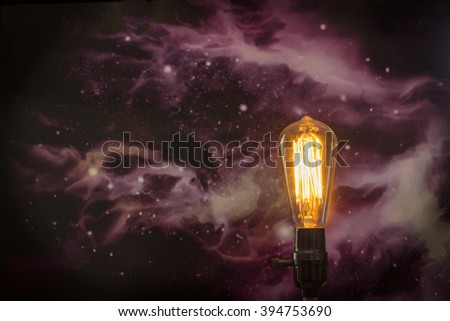 Decorative antique edison style filament light bulb with starscape background