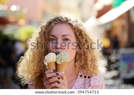 Portrait of beautiful happy smiling emotional young blonde woman with long curly hair eating delicious ice cream  different sorts sunny summer day outdoor in city, horizontal picture