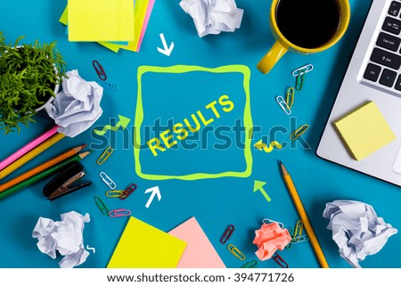 Results. Office table desk with supplies, white blank note pad, cup, pen, pc, crumpled paper, flower on wooden background. Top view