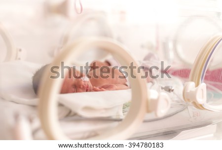 Premature newborn  baby girl in the hospital incubator after c-section in 33 week Royalty-Free Stock Photo #394780183