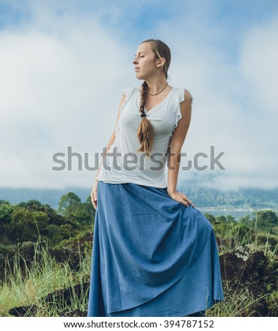 Young Woman looking on Batur volcano and Agung mountain view at morning from Kintamani, Bali, Indonesia