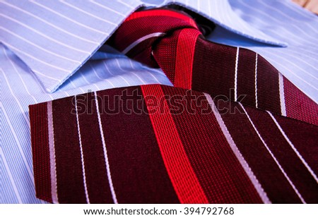 Luxury blue shirt with ornament with red striped tie. Business suit macro shot