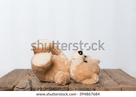 Teddy Bear toy alone on wood.