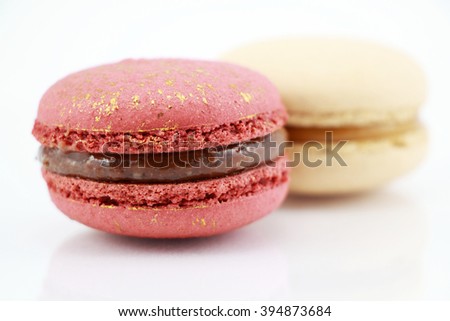 Impressive a gold-red and A pearly white, large-sized patterned macaron filled with mild sweet lychee ganache , raspberry jelly and chocolate packaged in a box 