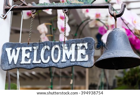 Welcome sign hung on the wall in garden.