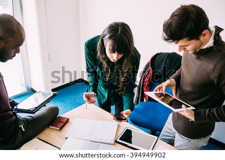 Group of contemporary multiethnic business people working together using multimedia devices like smart phone and tablet - working, business, start up concept Royalty-Free Stock Photo #394949902