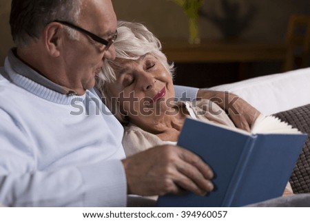 Cropped picture of an ederly couple reading a book