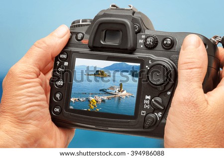 Photo of church and sea on camera display during the summer vacation. Travel photography.