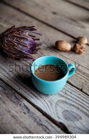 A Cup of coffee on wooden background, with flower and nuts. Romance, Breakfast in bed, compliments. Delicious beverage.