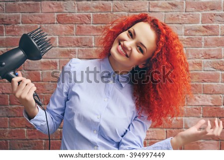 Red haired beautiful girl with hairdryer