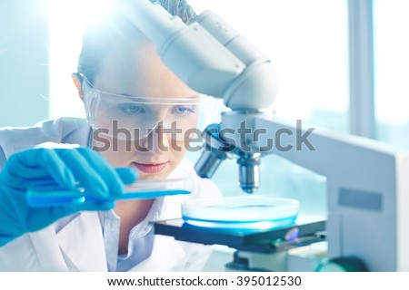 Female researcher using her microscope in a laboratory