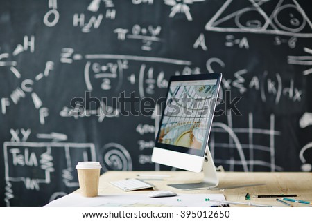 Computer on the table with blackboard in the background