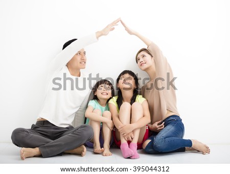 happy family sitting together and making the home sign Royalty-Free Stock Photo #395044312