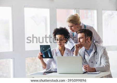Healthcare, medical: Group of multi-ethnic doctors discussing and looking x-ray in a clinic or hospital. 