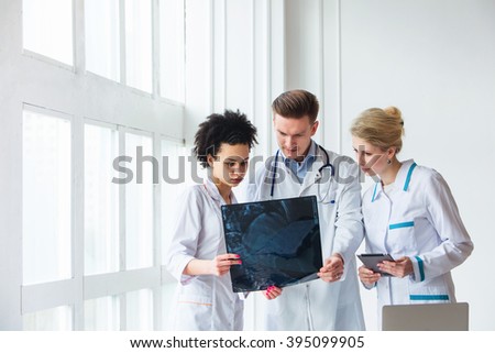 Healthcare, medical: Group of multi-ethnic doctors discussing and looking x-ray in a clinic or hospital. 