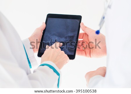 Healthcare, medical: Doctors looking x-ray on tablet pc.