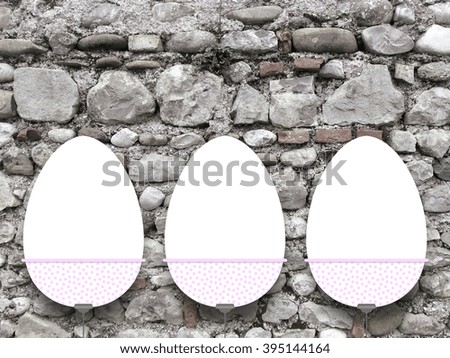 Close-up of one hanged decorated blank Easter egg frame against ancient stone wall background