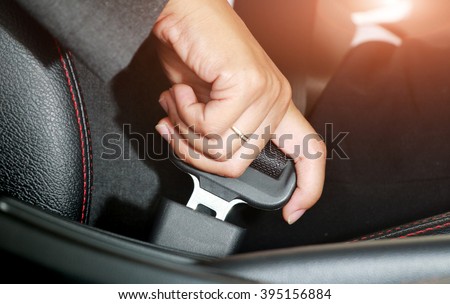Business woman hand fastening a seat belt in the car. Royalty-Free Stock Photo #395156884