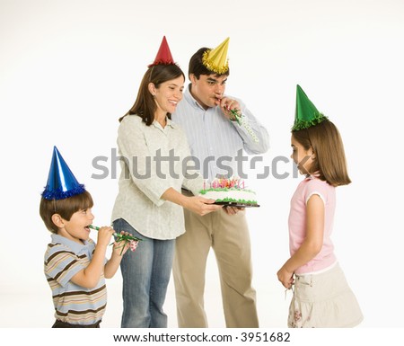Family celebrating girl's birthday with cake.