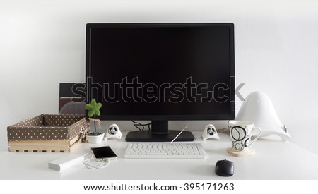 Office desk table with computer, supplies, green small plant, technology devices in white room
