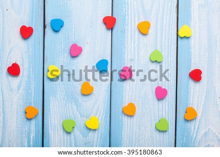 Blue wood background with color heart shapes. Closeup. Top view for festive or celebration themed concepts.