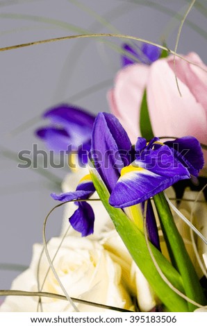 Delicate beautiful bouquet of  iris, roses and other flowers in 