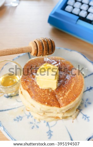 Thick pancakes with honey syrup and butter on top, wooden table background. Pancake week, mardi gras, maslenitsa holidays