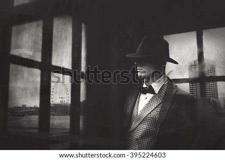 elegant gangster man behind window looking at the city Royalty-Free Stock Photo #395224603
