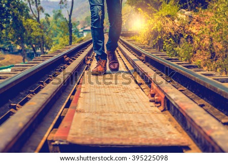 Man jeans and sneaker shoes walking on Railroad Royalty-Free Stock Photo #395225098