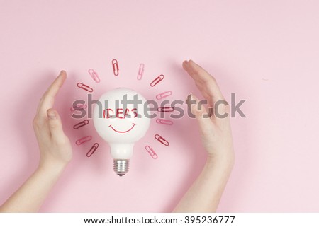 new idea concept with crumpled office paper, female hand holding light bulb.