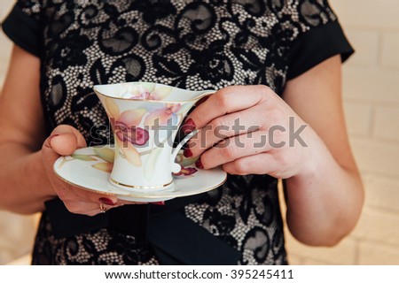 woman holding cup of tea and smiles