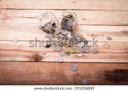 coins money in glass bottle on wooden background