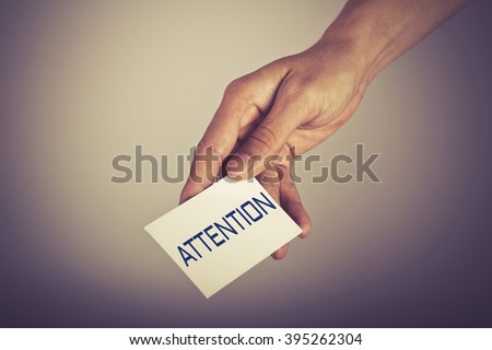 " Attention " word on card hold by man