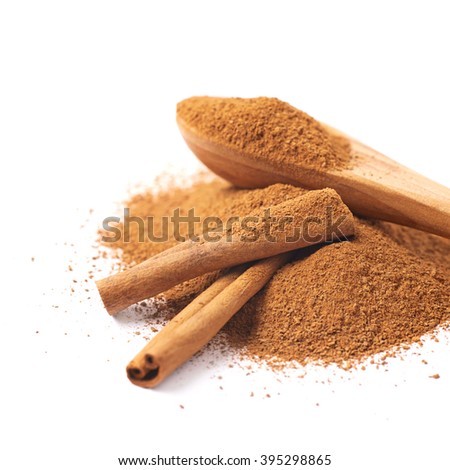 Pile of cinnamon powder with the wooden spoon and raw bark sticks on top of it, composition isolated over the white background