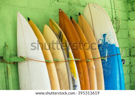 Set of different color surf boards in a stack by ocean.Bali,Indonesia. Surf boards on sandy Weligama beach. On Weligama beach surf is available all year around for beginner and advanced. Royalty-Free Stock Photo #395313619