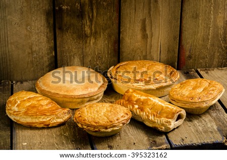 Selection of Pies, Pasties and sausage rolls on a wooden background. Royalty-Free Stock Photo #395323162