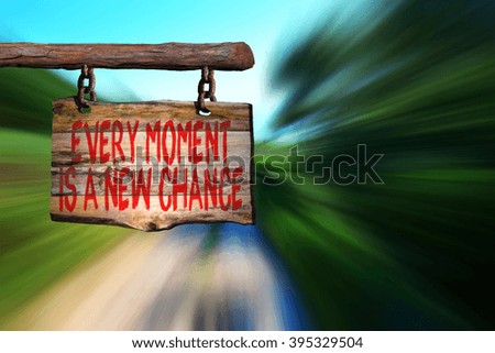 Every moment is a new chance motivational phrase sign on old wood with blurred background